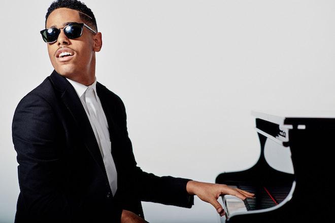 Matthew Whitaker sitting at a black grand piano