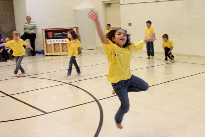 The Side by Side program from Tanner Dance Children wearing t shirts dance in a school recreation room