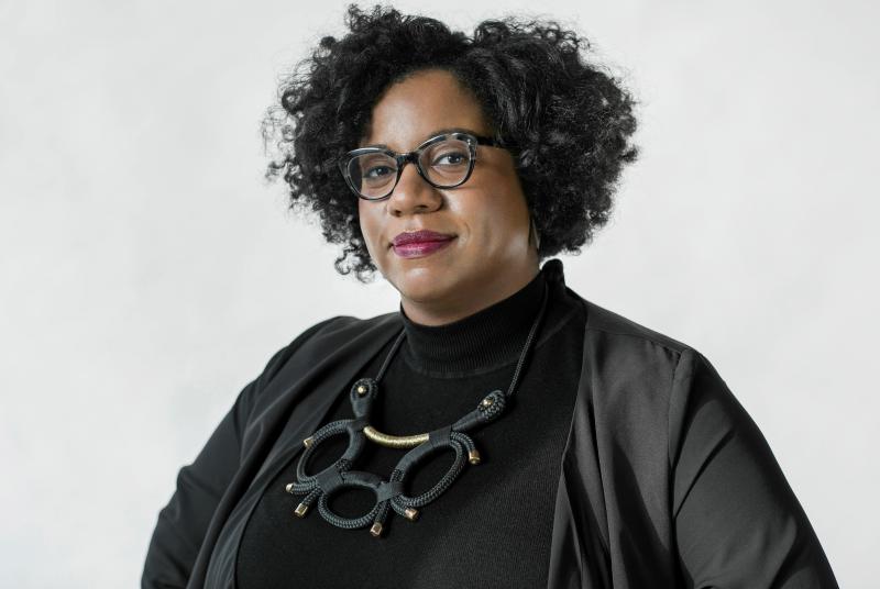 Gina Duncan A woman with black curly hair and funky glasses
