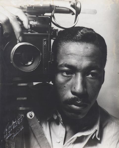 self-portrait of photographer Gordon Parks holding a camera