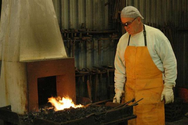 An artist working at a blacksmithing coal forge An artist working at a blacksmithing coal forge