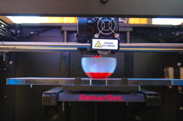 A 3D printer at work creating a bowl A 3D printer at work creating a bowl