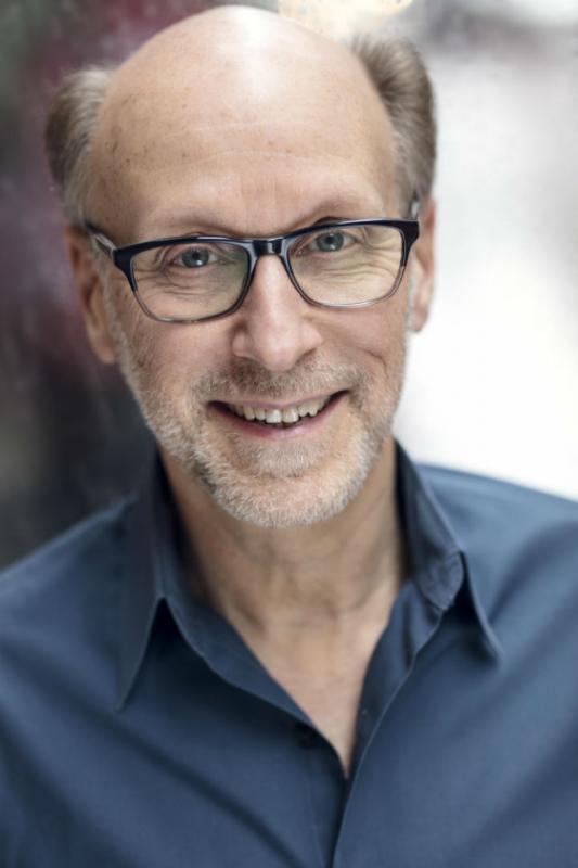 Man with glasses and blue shirt smiling
