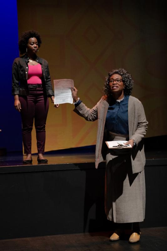A scene from Lawbreakers! An actress asks a young audience whether anyone needs a voter registration card