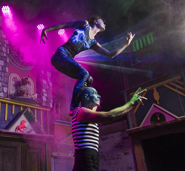 Performers at Meow Wolf Acrobat standing atop another acrobats shoulders