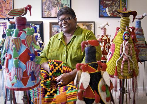 Carolyn Mazloomi African-American woman surrounded by quilts.