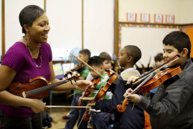 A violin teacher leads a class of violin students
