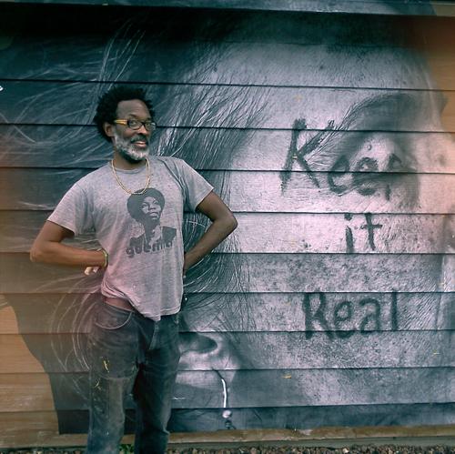 African-American man standing in front of his mural.