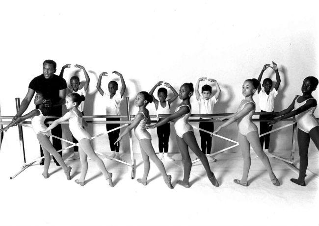 Arthur Mitchell teaches a class of young ballerinas Man instructing young ballerinas at ballet barre