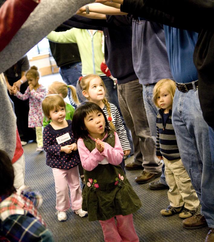 Kids going under a bridge of adult arms. 