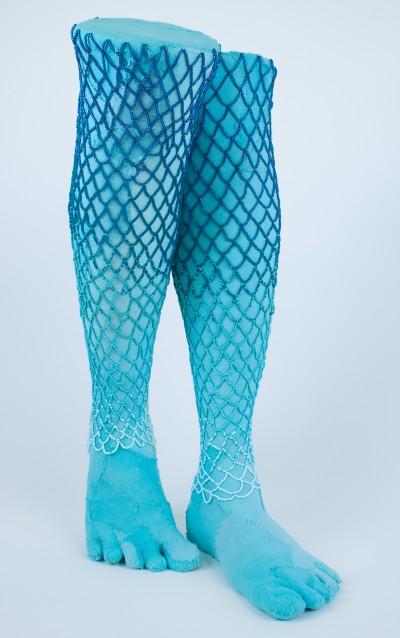 A sculpture of blue legs overlaid with blue beaded netting
