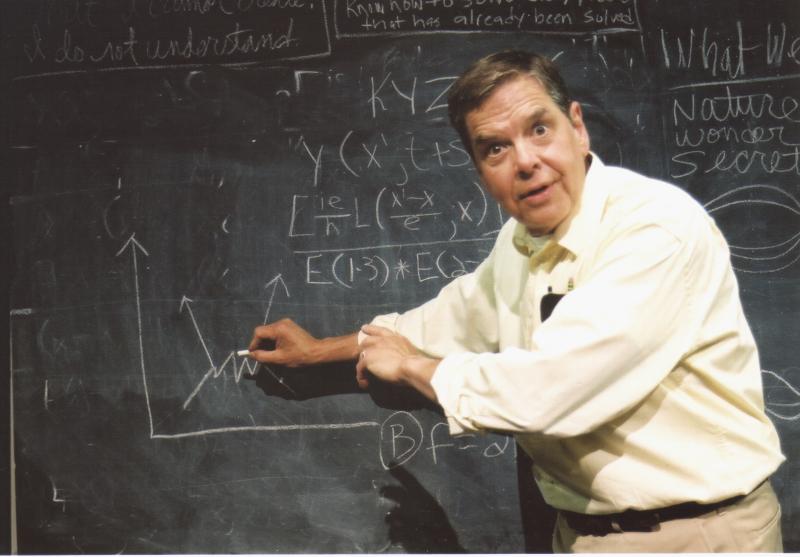 Peter Parnell’s play QED Man standing at chalkboard full of mathematical equations.
