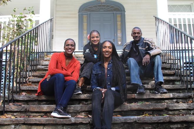 Four of Lucille Clifton's children sit on the concrete steps at the front of a large house