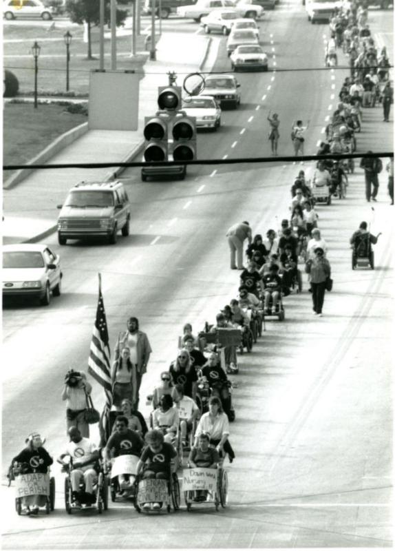 Disability rights protest in Atlanta, 1990 A long column of people in wheelchairs march down the street protesting for disability rights