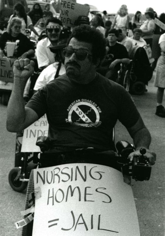People in wheelchairs with protest signs People in wheelchairs with protest signs