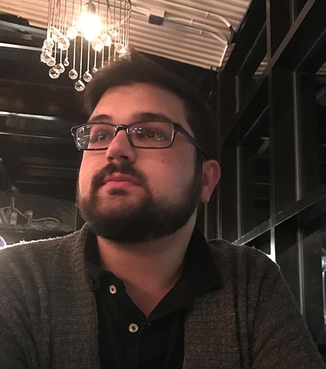 Man with dark beard and glasses