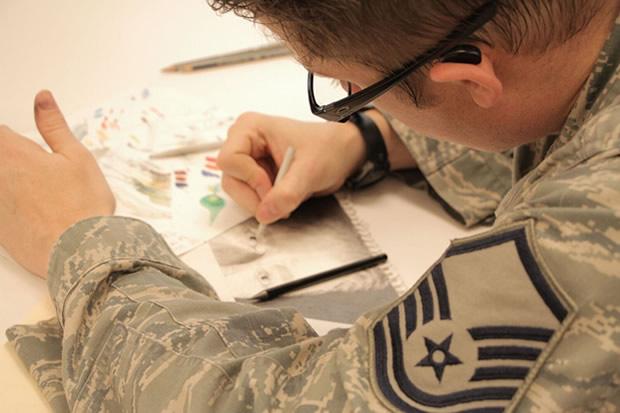 Photo over the shoulder of a soldier drawing