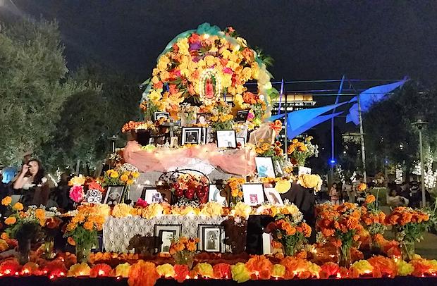 A large flower altar in an outdoor setting at night.