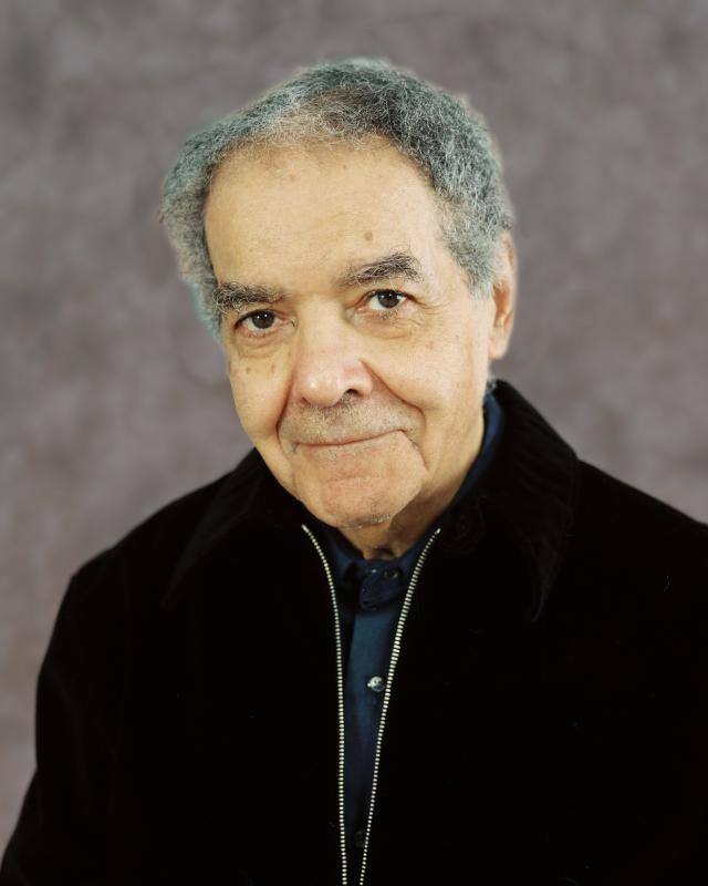 Portrait of man with short gray hair wearing a black jacket. 