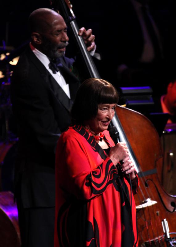 Ron Carter and Sheila Jordan A man performs on the bass next to a woman in a red dress singing into a microphone