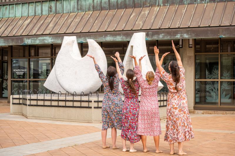 Four women with hands raised