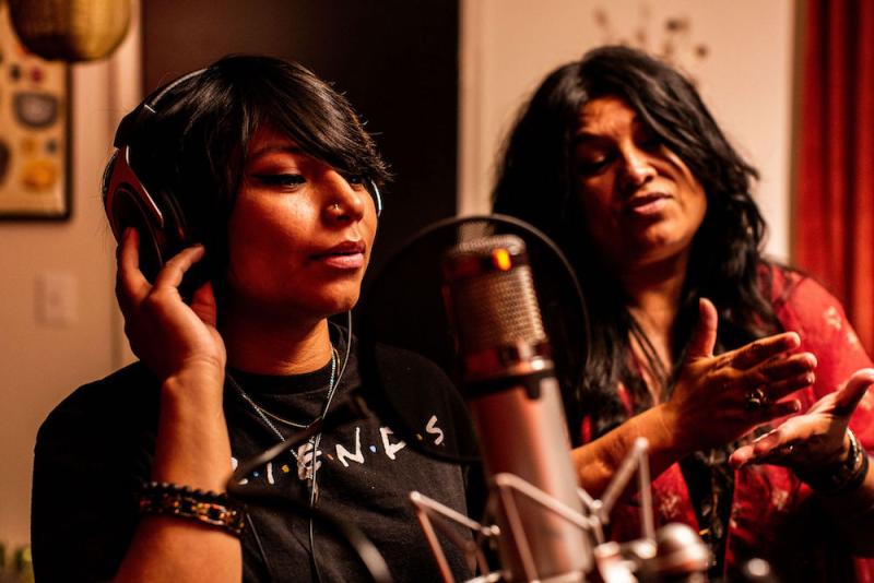 a girl and a woman working in a recording studio