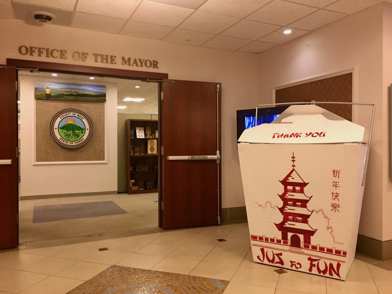 A large Chinese food container sits outside a doorway that reads "Office of the Mayor"