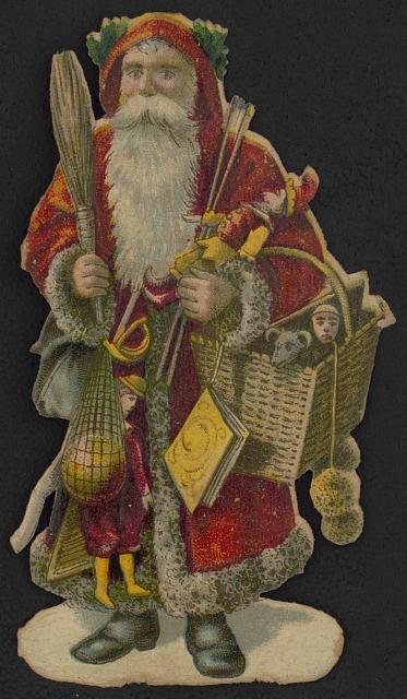irregular shaped die cut Christmas decoration showing Santa Claus, full-length portrait, facing front, carrying toys with his arms and in a basket.