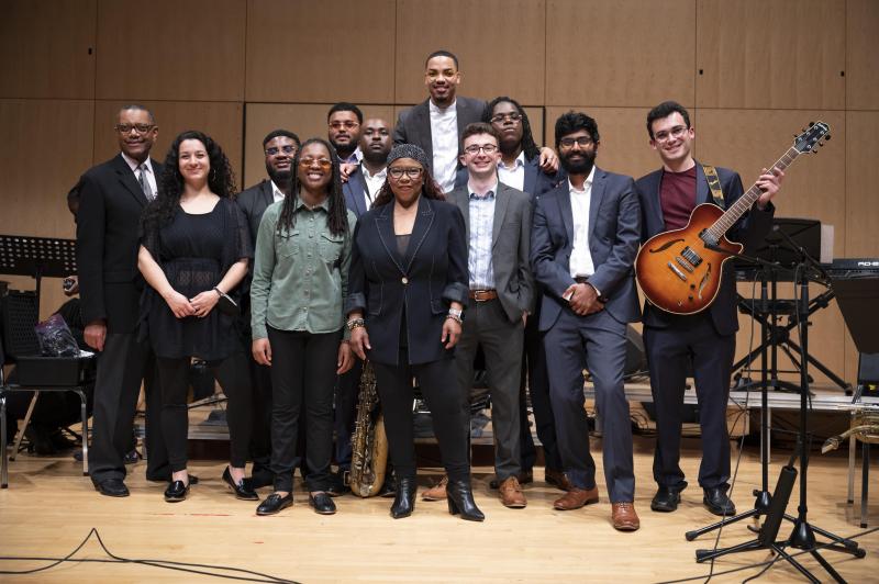 Several men and woman gathered on stage and smiling front and center.