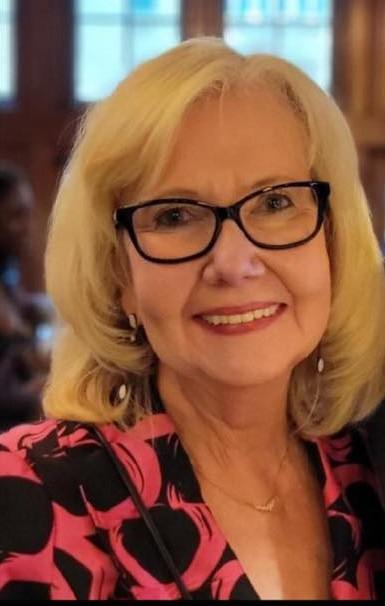 NEA Director of Music and Opera Ann Meier Baker an older white woman with shoulder length blonde hair and glasses smiles gently at the camera