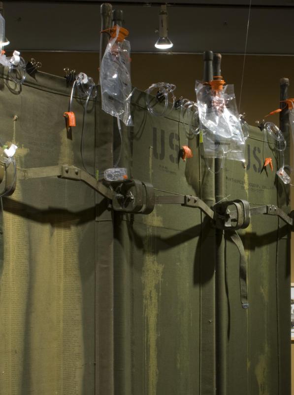 detail of work that comprises "blood stains" silk screened onto military stretchers
