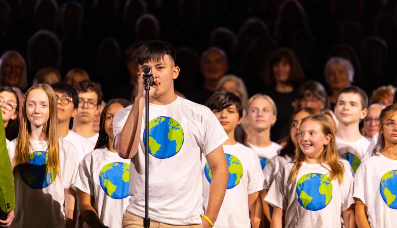 Photo of a group of kids singing on stage