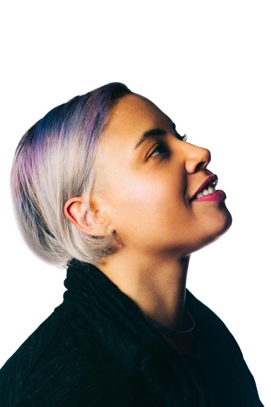 a light skinned woman with a short bob with streaks of purple