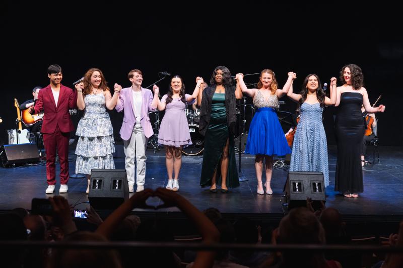 2024 Musical Theater Songwriting Challenge winners, from left to right: Owen Yeh-Lee, Luisa Paraguassu, Maya Johnson, Isabella Nguyen, Tabitha Moore, Sydney Gray, Ale Fonseca, and Gwendellyn Doerfler holding hands on stage