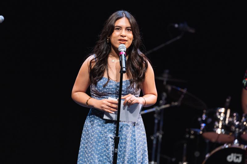 Ale Fonseca standing behind a microphone