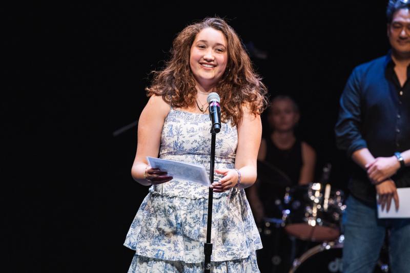 Luisa Paraguassu standing behind microphone
