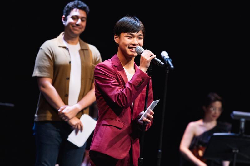 Owen Yeh-Le standing behind a microphone