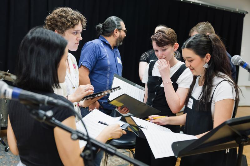 Maya Johnson and Isabella Nguyen providing feedback during rehearsals of their original song, "Live Before Life’s Gone."