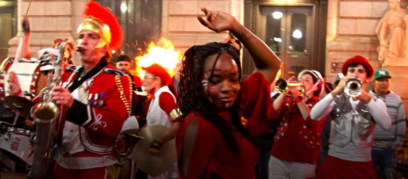 Nightime outdoor event with musicians and a dancer in the middle