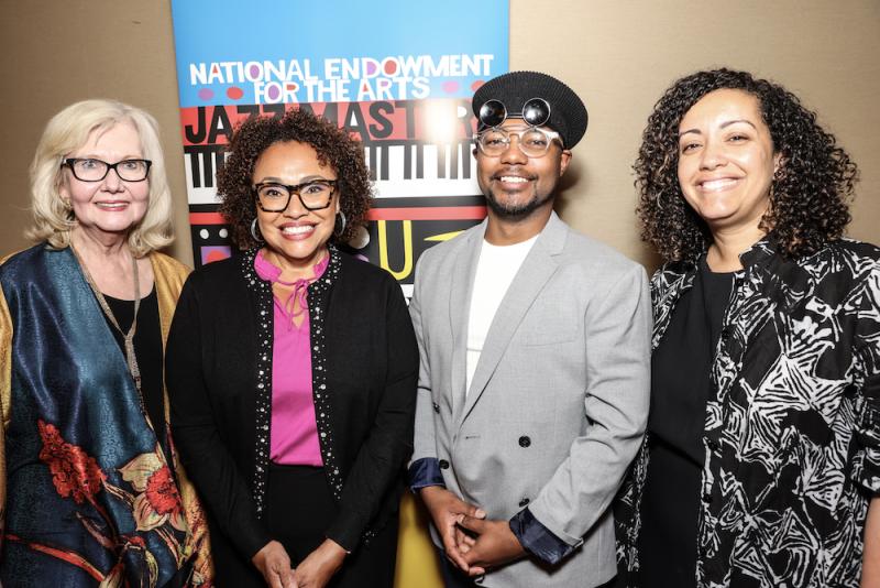 photo of three women and one man standing in front of NEA Jazz Masters signage