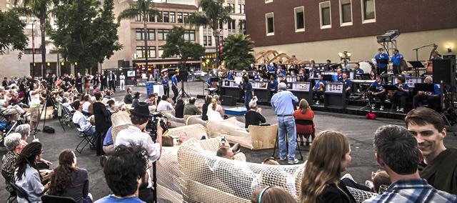 Large crowd on an outdoor plaza at a music installation event