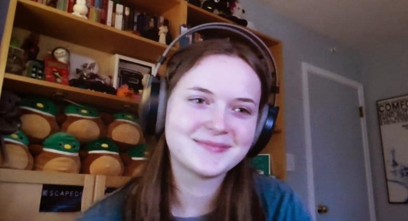 Headshot of a woman with headphones, smiling.