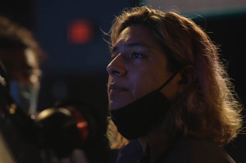 Native man with a black mask hanging at the bottom of his chin.