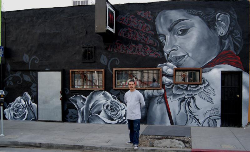 A man stands before a mural.ural