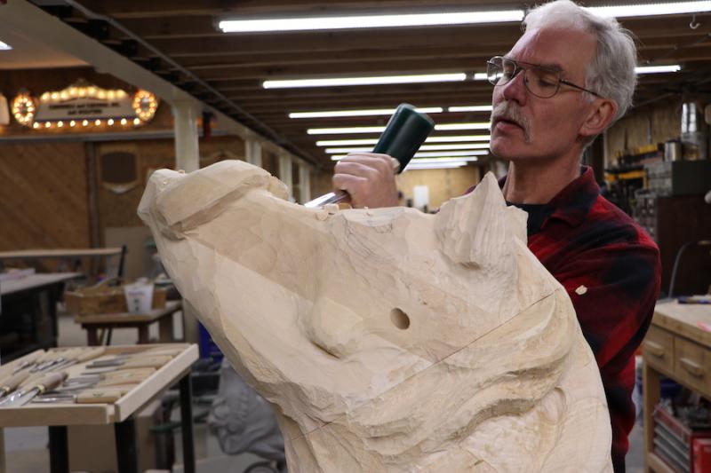 Man carving a pigs head.