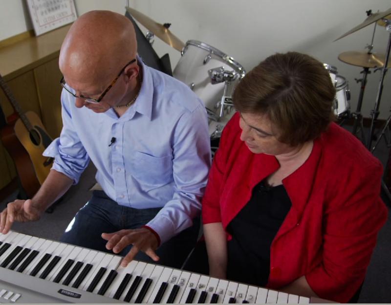 A music therapist  works with a patient recovering from a stroke