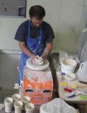 Potter William Baker shapes a new piece on the wheel in his studio; Baker is one of the local artists that North Carolina's HandMade in America has brought visibility to with its guidebooks and online resources.