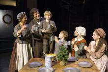 Tiny Tim toasting Christmas with his family from A Christmas Carol