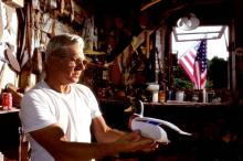 Man holding carved decoy of a duck.