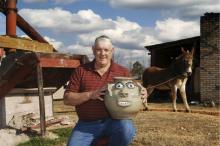 man kneeling outside with face jug